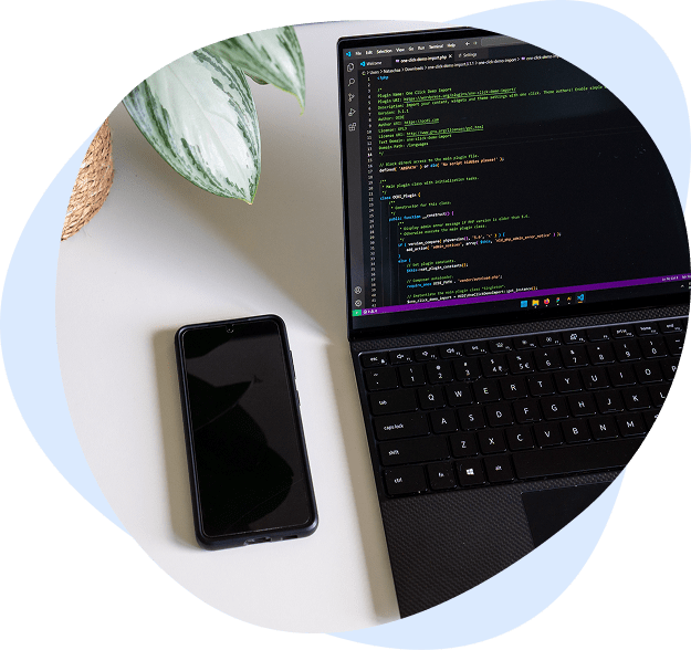 Laptop staat open met code en telefoon ligt op het bureau